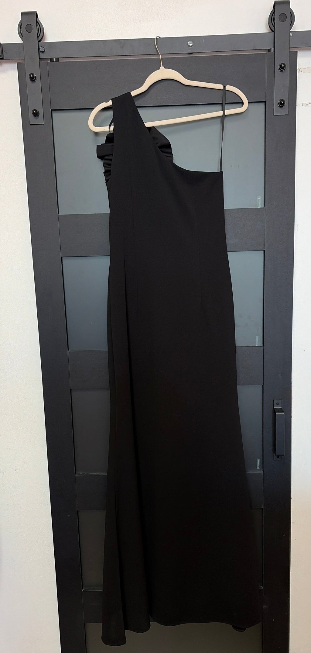 Betsy & Adam black one shoulder gown with floral detail across chest